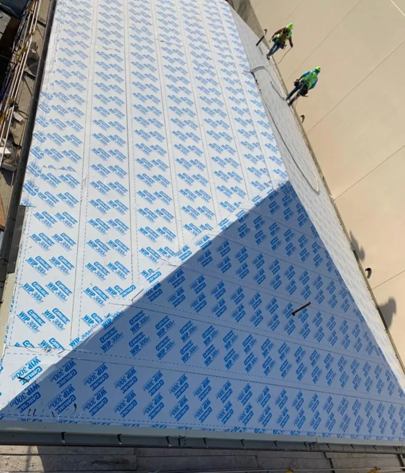 Professional roofers installing underlayment on a metal roof in Atlantic